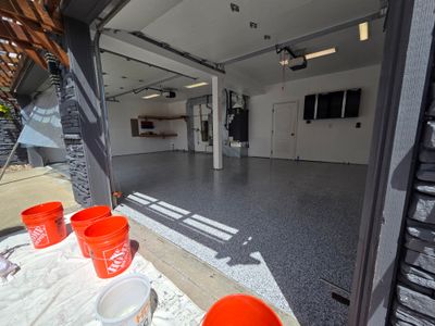 The same garage finished, with a gray and black flake floor under a gloss topcoat